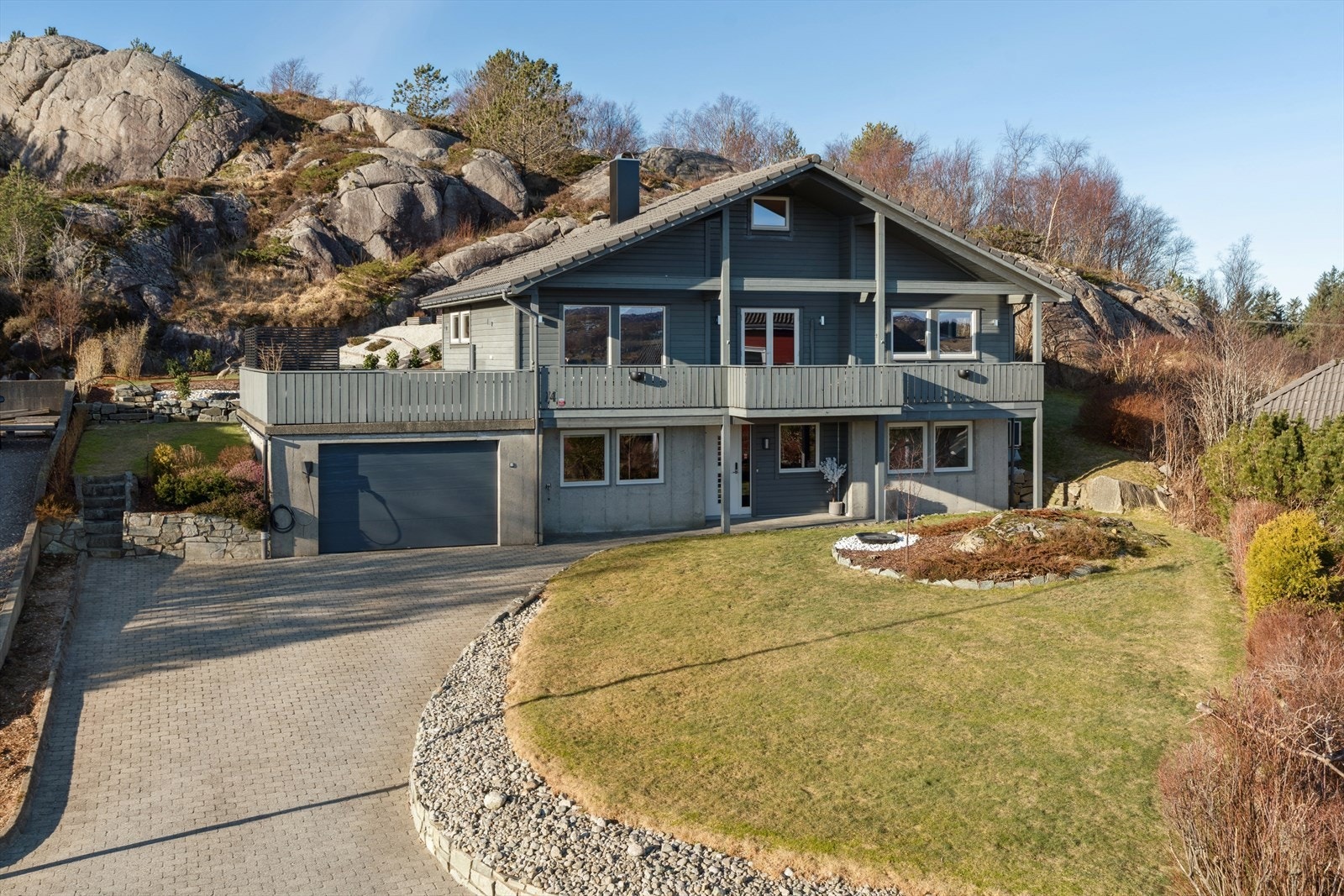 Her bor du med kort avstand til det du trenger i hverdagen - Tomten fremstår svært tiltalende, med velstelte plener, vakker beplantning, solide støttemurer og flott belegningsstein i gårdsrommet. Galleribilde