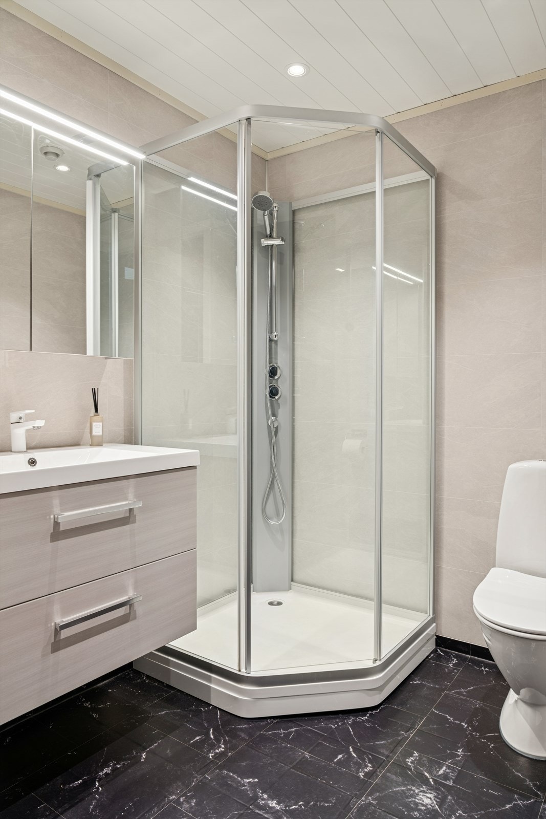 Bad med ny baderomspanel på vegg og smartpanel i taket. Rommet er innredet med dusjkabinett, toalett, seksjon med servant. Galleribilde