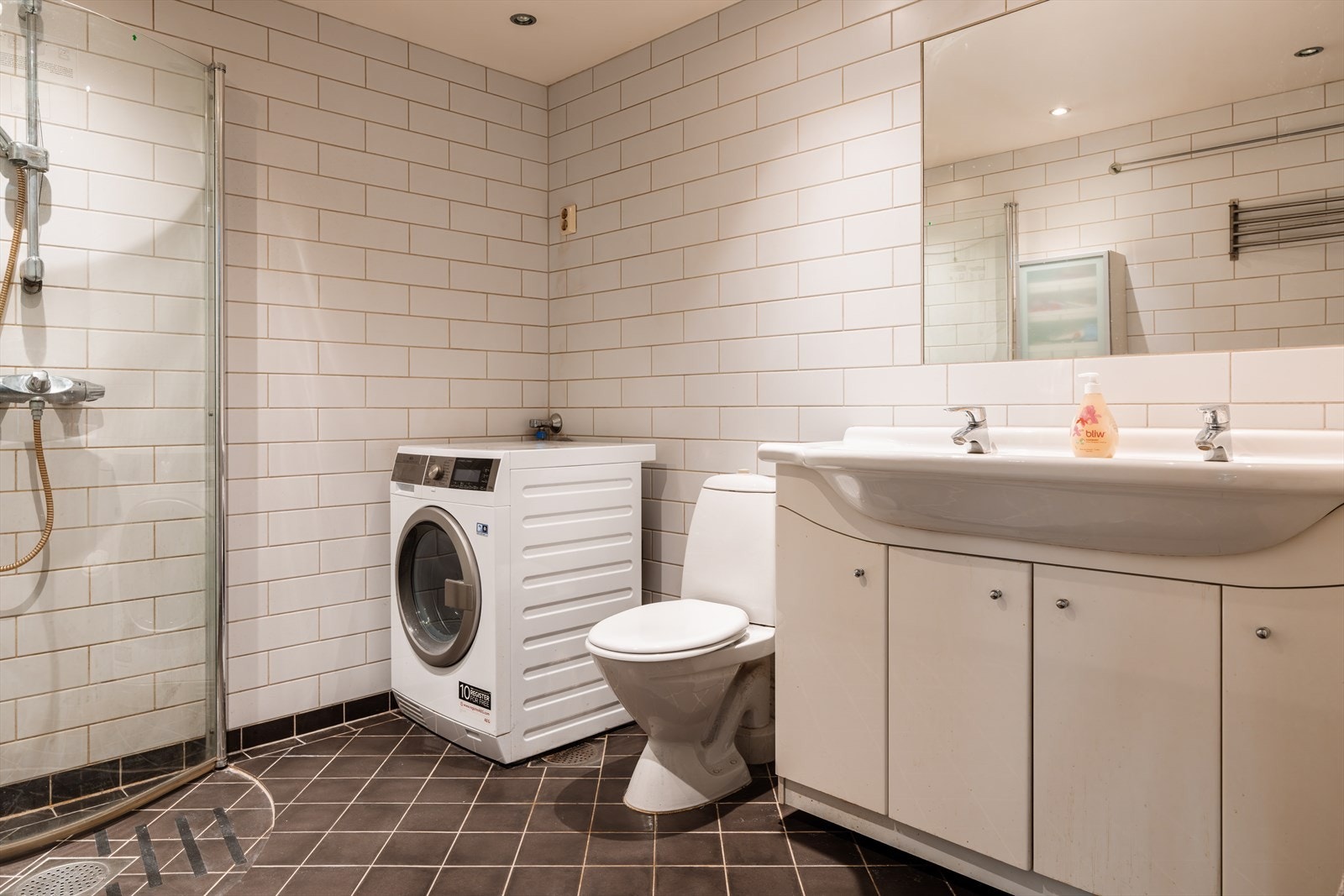 Et lyst og romslig baderom med flislagte overflater og varme i gulvene. Galleribilde