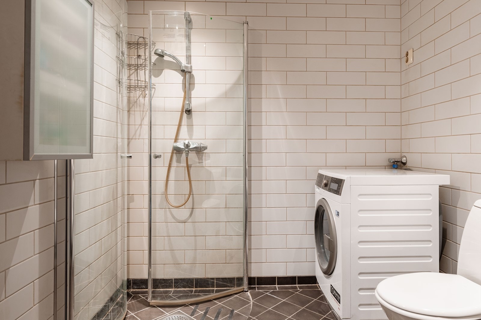 Dusjen er plassert på gulv bak innfellbare dusjdører. Galleribilde