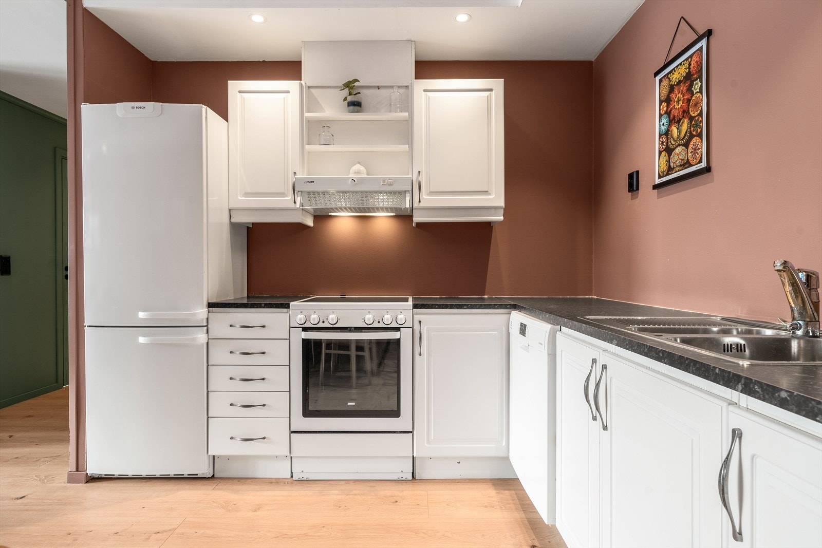 Kjøkkeninnredningen er i praktisk L-form for rikelig med benkeplass. Galleribilde