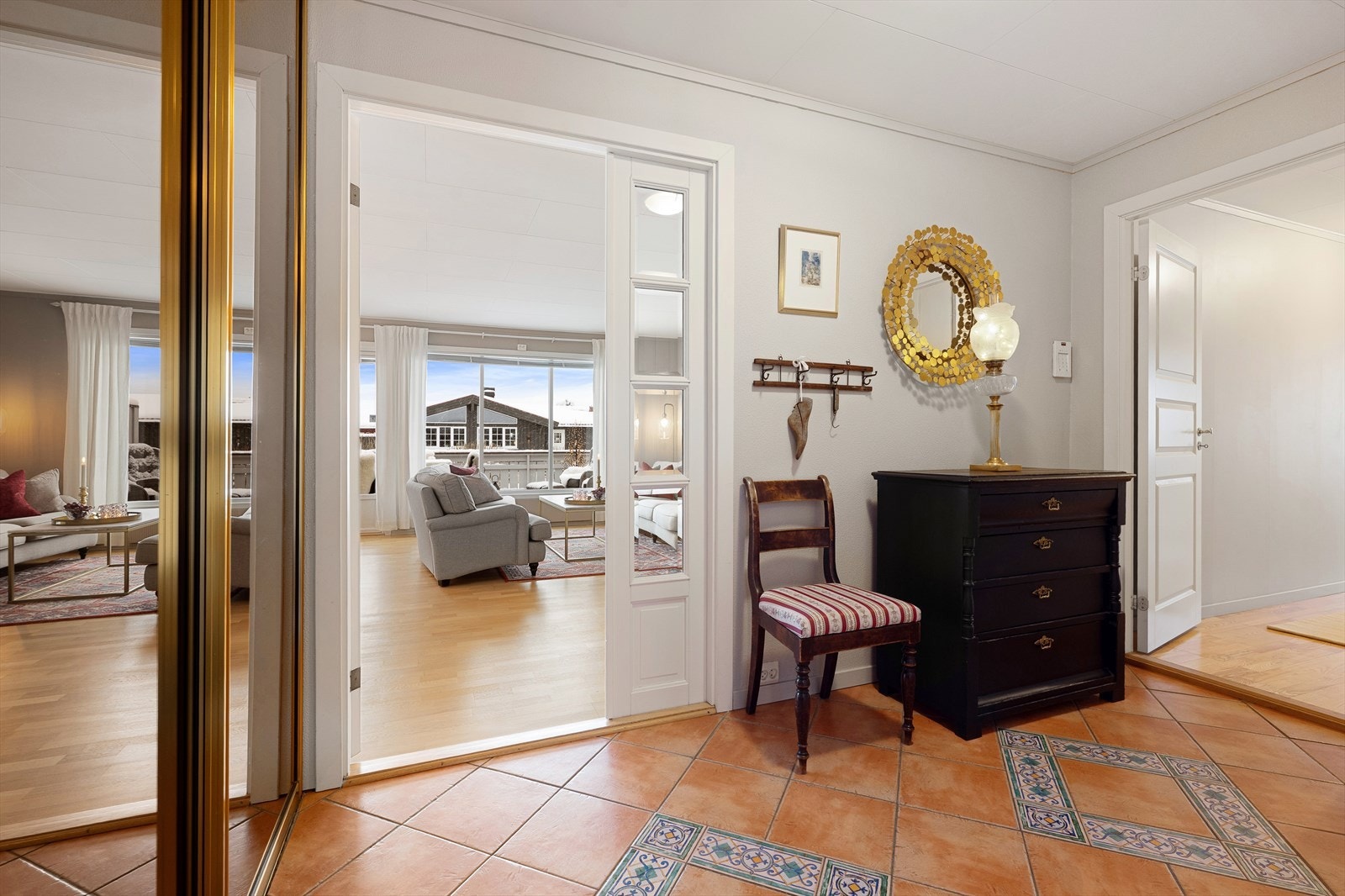 En tofløyet dør med glassfelt åpner fra gangen og inn til den store stuen. Galleribilde