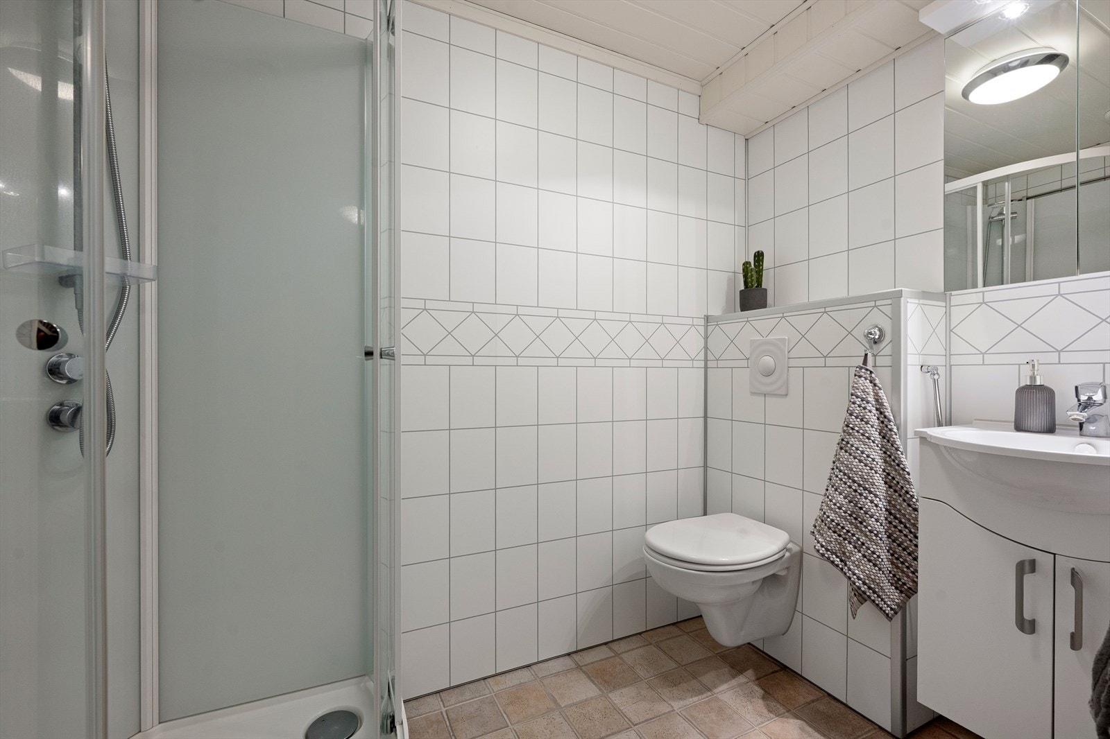 Badet i kjelleren er utstyrt med dusjkabinett, vegghengt toalett og servant. Badet ble oppgradert i 2011. Galleribilde