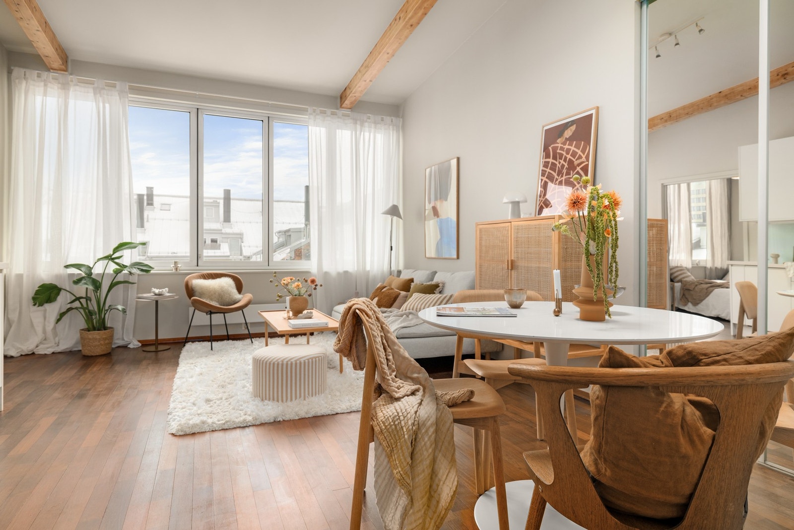 Leiligheten har åpen stue-/kjøkkenløsning med god takhøyde for en luftig atmosfære. Trebjelkene i taket gir også et stilig preg til leiligheten. Galleribilde