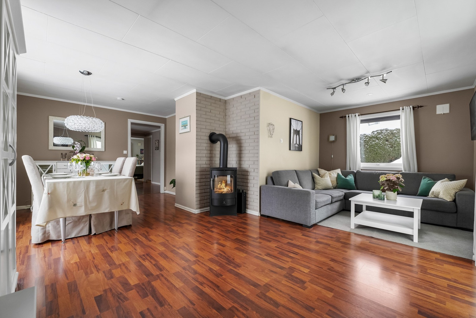 Lys , trivelig og romslig vinkelstue med peis som gir god varme i den kjølige årstiden Galleribilde