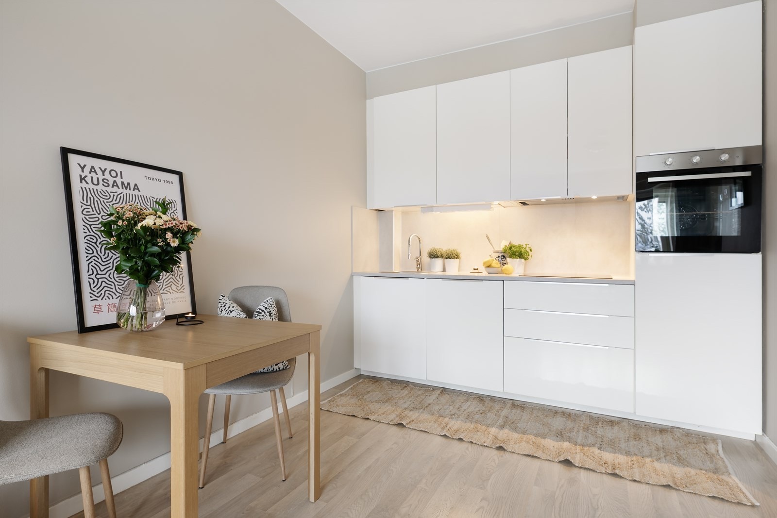 Stilren kjøkkeninnredning fra IKEA med hvite fronter og laminat benkeplate. Det er godt med oppbevaringsplass i skuffer og skap som gjør det enkelt å holde orden. Galleribilde