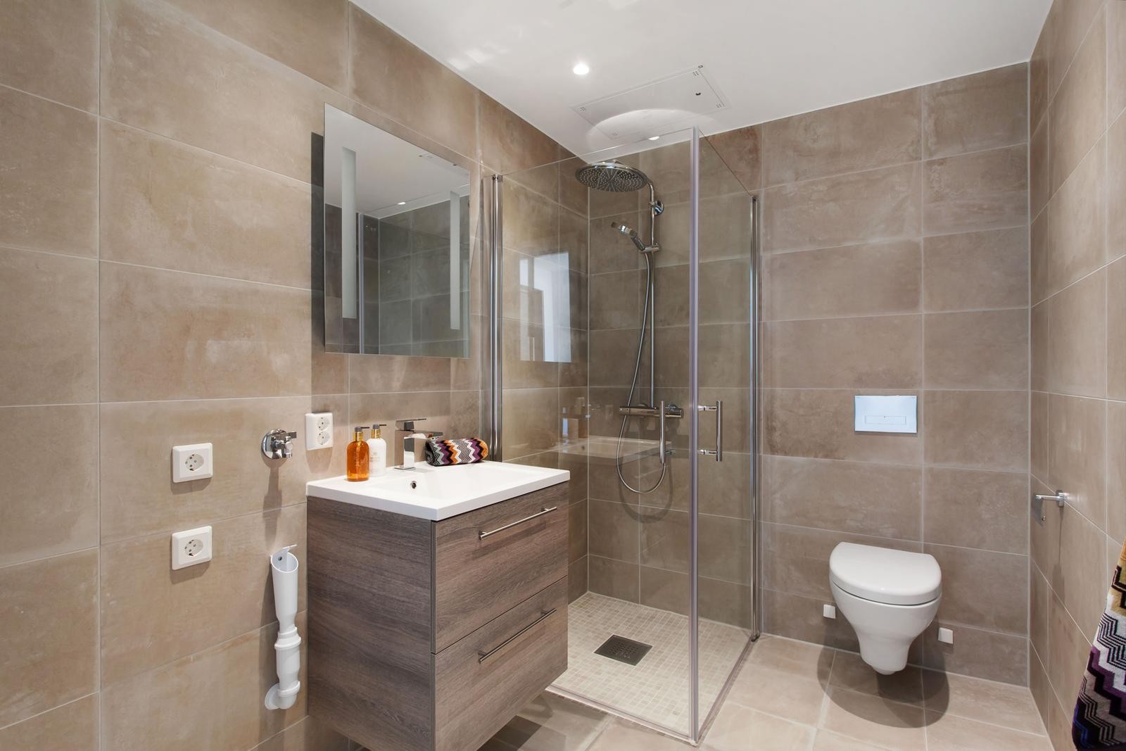 Lekkert, flislagt bad med opplegg for vaskemaskin Galleribilde