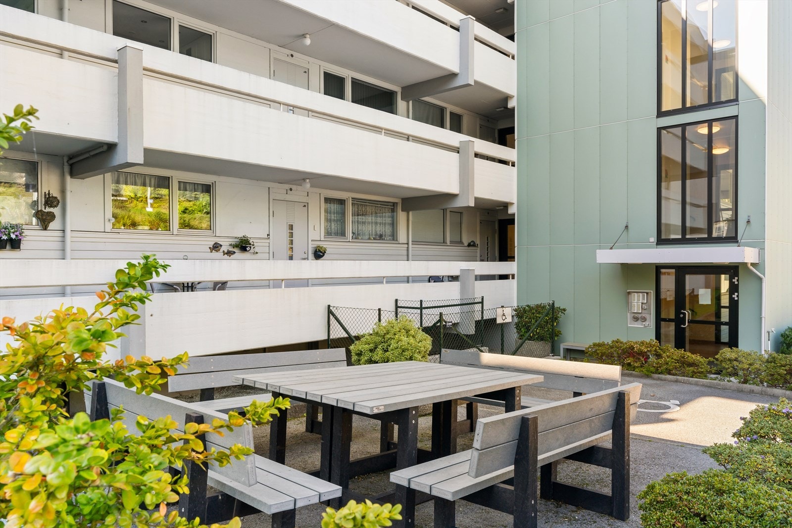 Pent opparbeidet felles tomt for borrettslaget med grøntområder, aktivitet, gangstier, carporter og sittegrupper Galleribilde