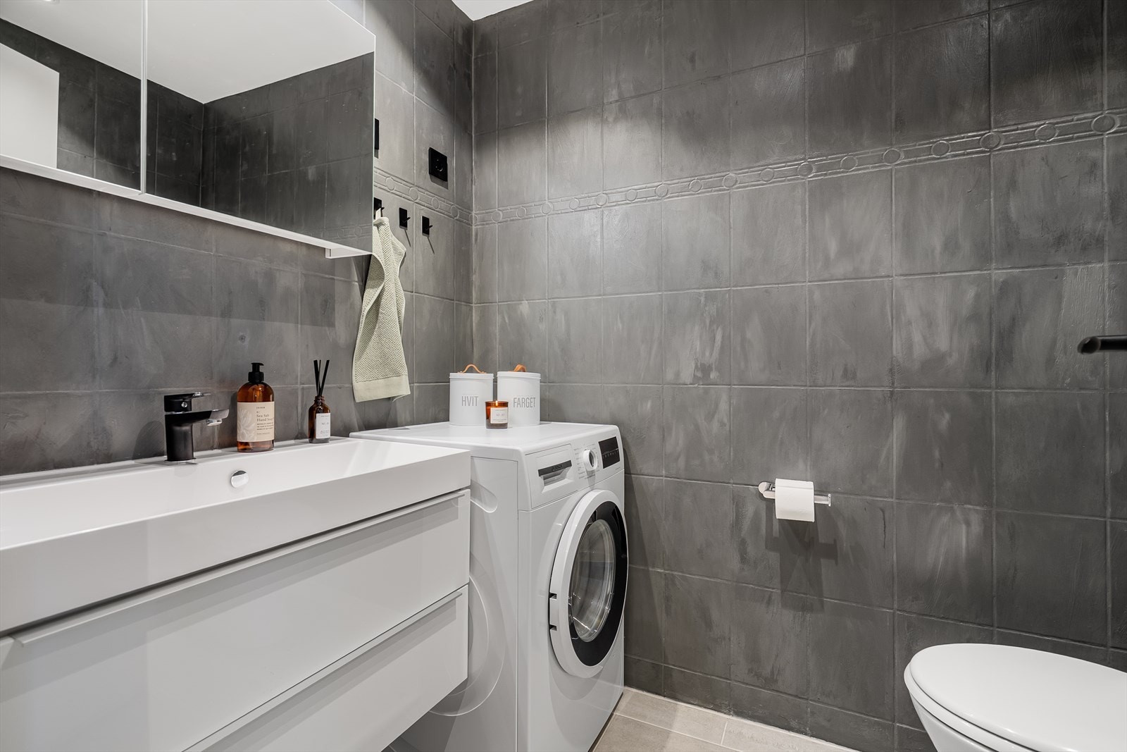 Flislagt bad med varmekabler i gulvet. Badet har toalett, baderomsservant, dusjkabinett og vaskemaskin Galleribilde