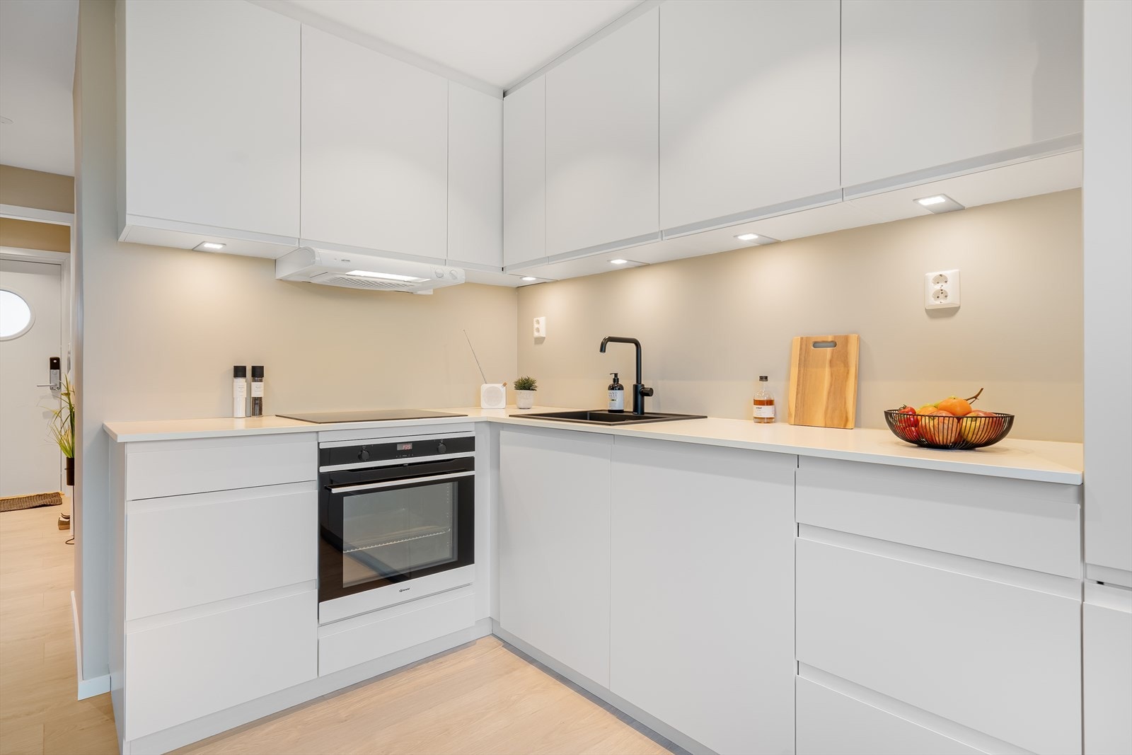 Lys Innredning på kjøkkenet, med glatte fronter og nedfelt kum. Integrerte hvitevarer Galleribilde