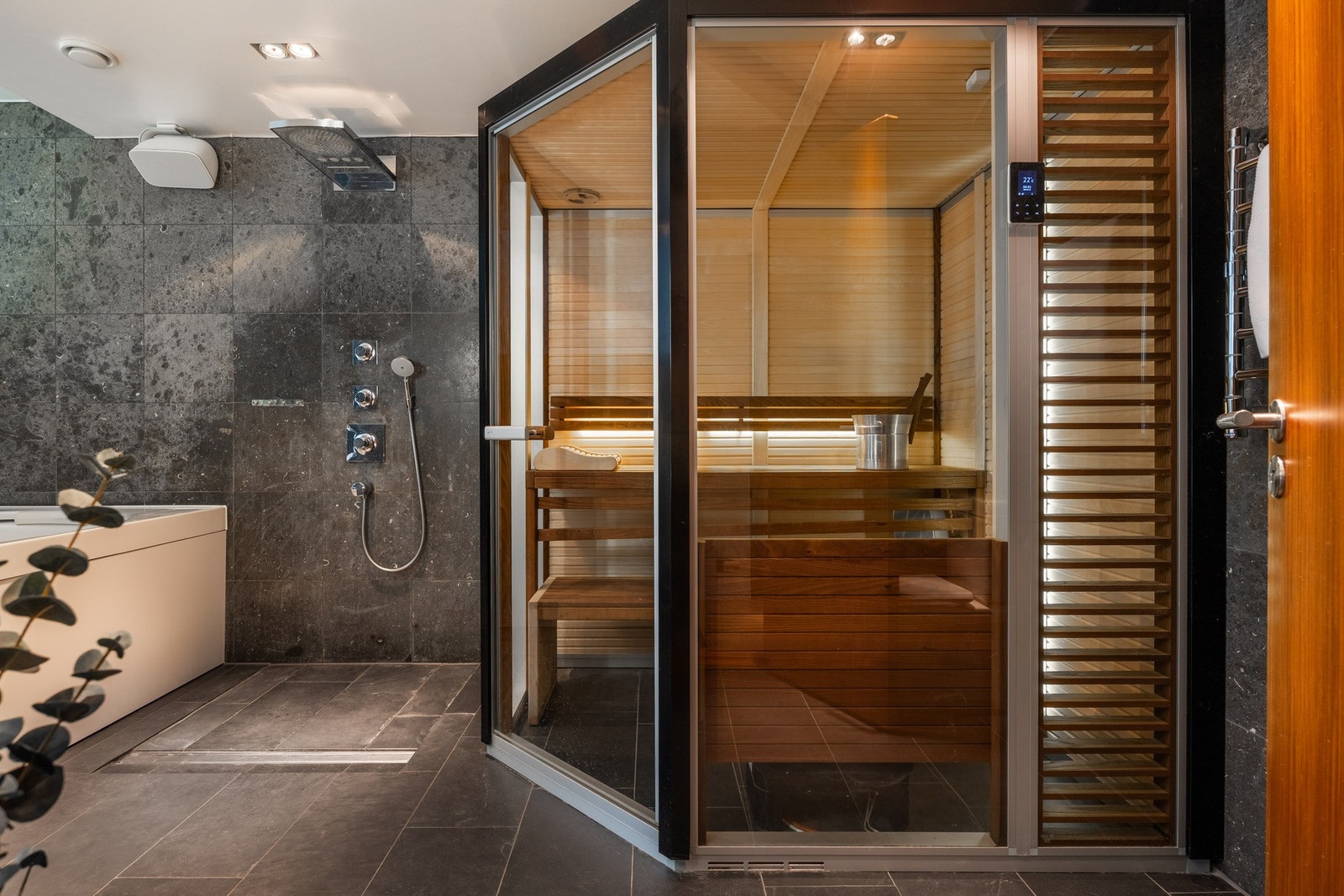 Stilrent baderom med en avslappende spafølelse, belagt med eksklusive natursteinfliser. Galleribilde