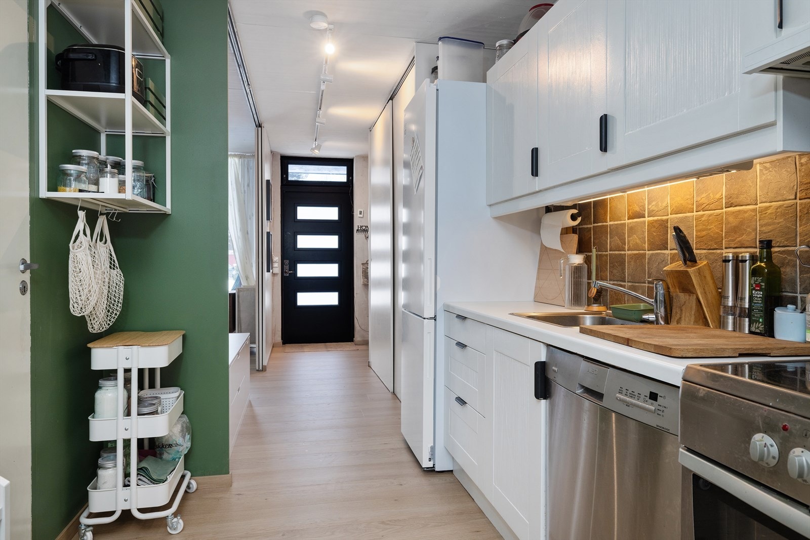 Kjøkkenet har frittstående hvitevarer som oppvaskmaskin, kjøl/frys og stekeovn. Galleribilde