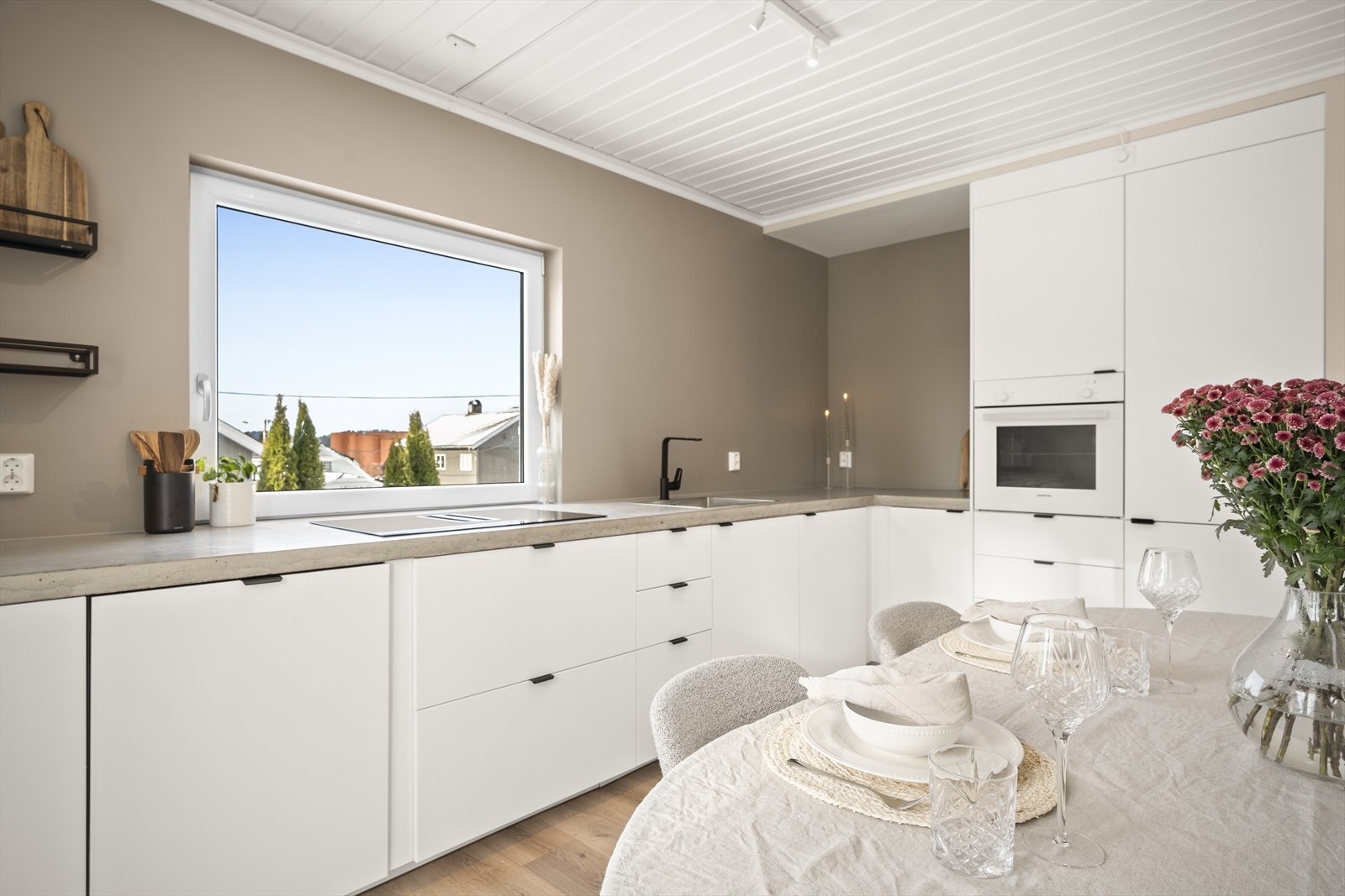 Pent kjøkken fra 2022 med integrerte hvitevarer og solid benkeplate i betong Galleribilde