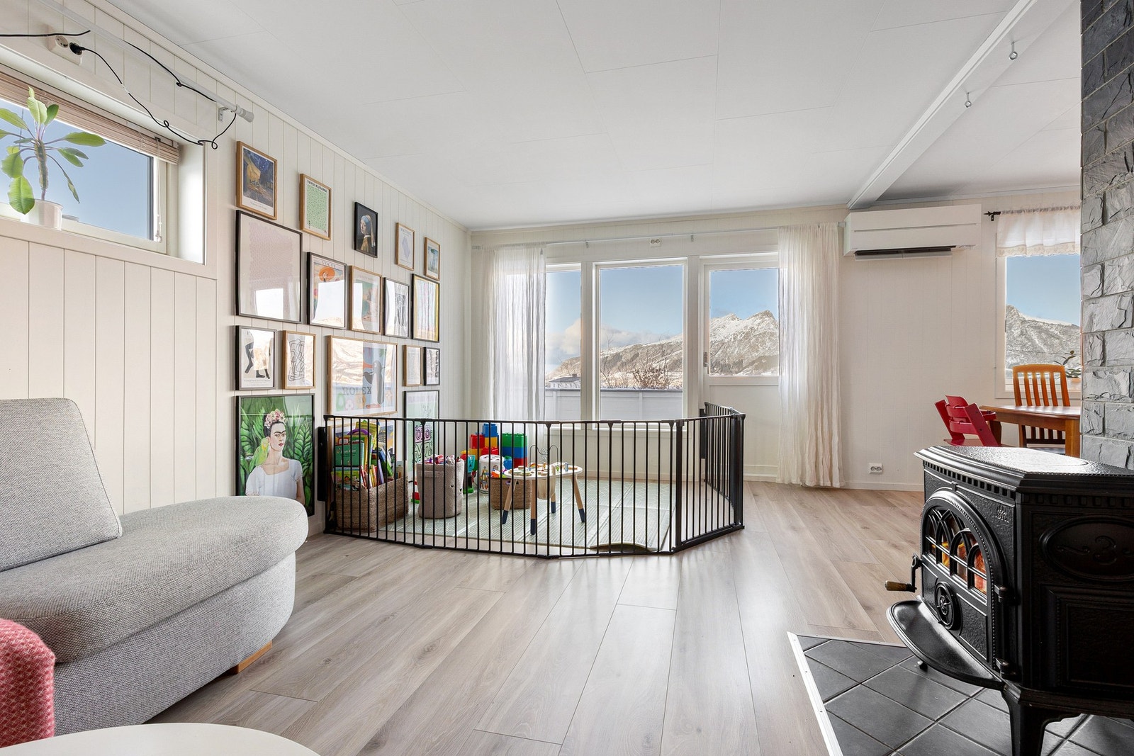 Oppholdsrommet er utstyrt med både vedfyring og varmepumpe - og det er utgang til solrik balkong som strekker seg rundt vestsiden av huset. Galleribilde