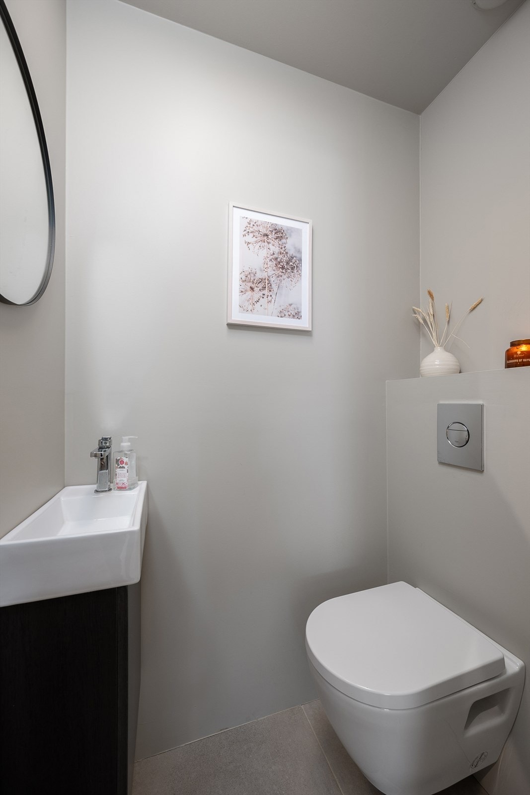 Praktisk toalettrom i første etasje med vegghengt toalett og flislagt gulv. Lyst og delikat. Galleribilde