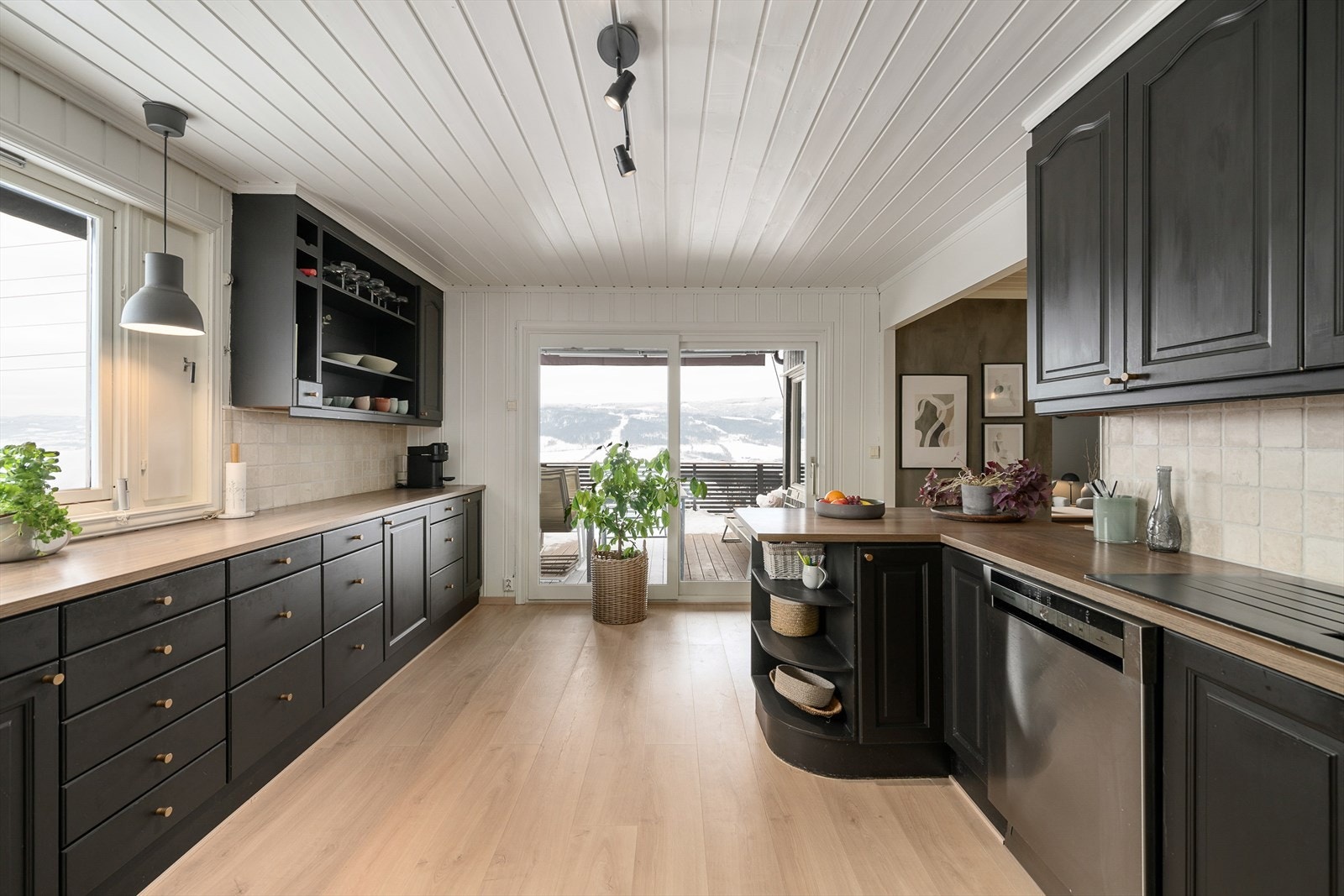 Fra kjøkkenet er det direkte utgang til en vestvendt veranda på 23 m² via en heve-/skyvedør. Det er i tillegg direkte adkomst mellom kjøkkenet og carporten. Galleribilde