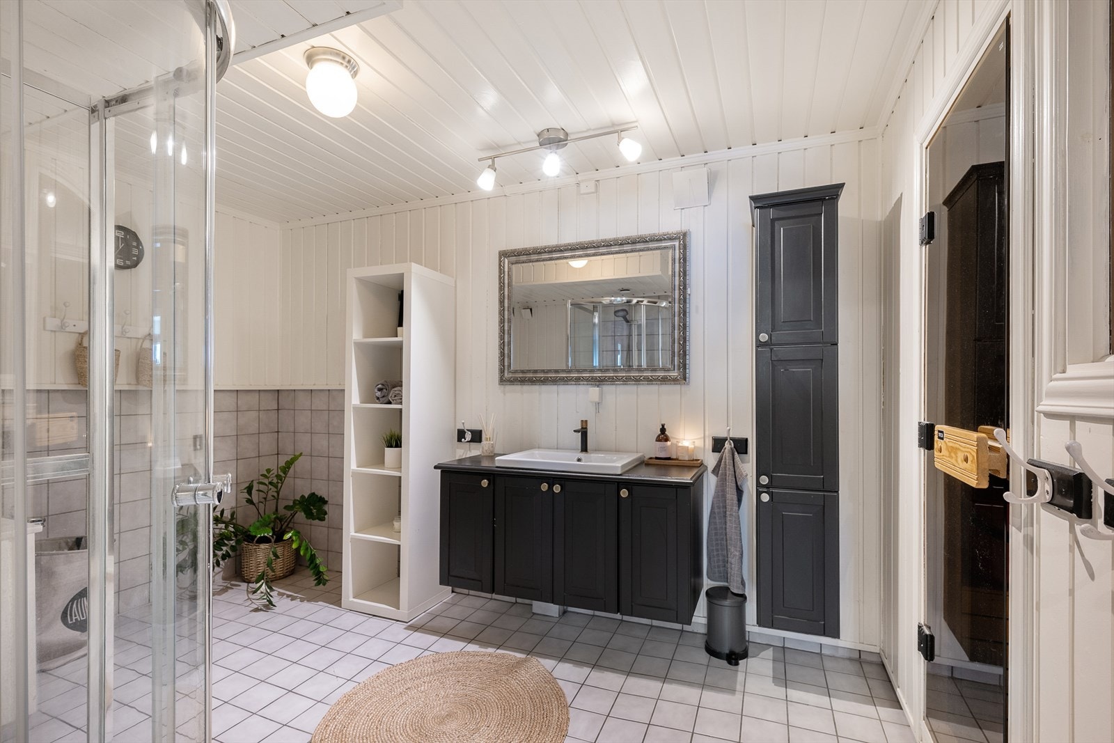 Bad i underetasjen med flislagt gulv med gulvvarme og dusjdører i herdet glass. Galleribilde