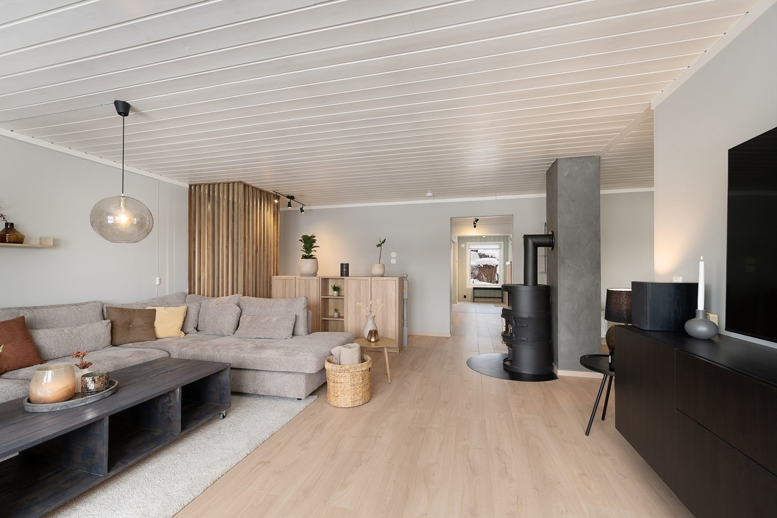 En sentralt plassert vedovn sørger for den ekstra gode varmen i stua. Ovnen er tilknyttet en elementpipe med nytt pipebeslag fra 2023. Galleribilde