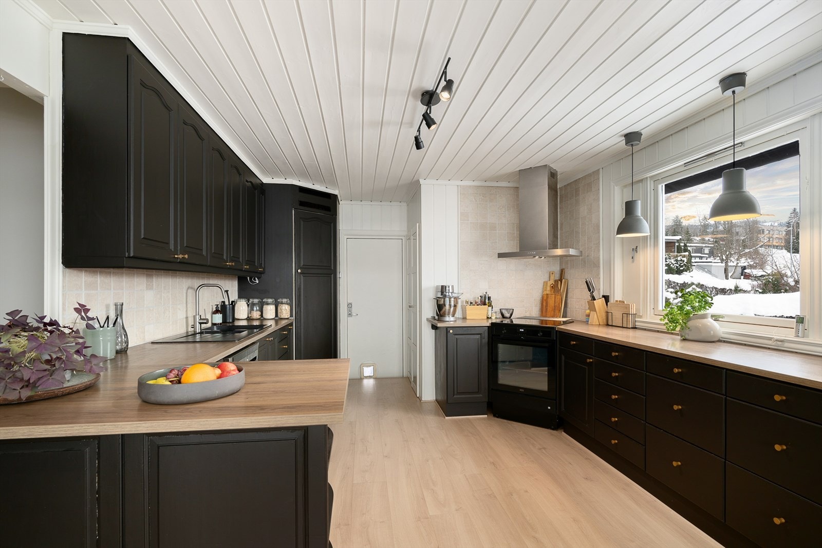 Laminat benkeplate med god arbeidsflate og plass til komfyr og oppvaskmaskin. Fint lys inn i rommet. Galleribilde