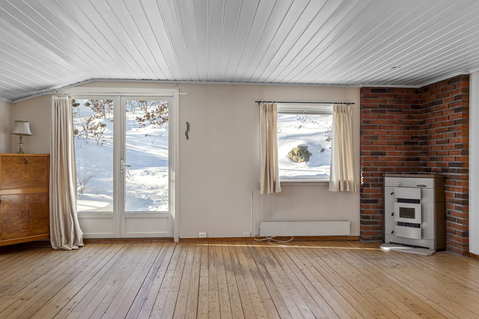 Det er utgang fra stue til en fin uteplass med plen, terrasse og utepeis. Galleribilde