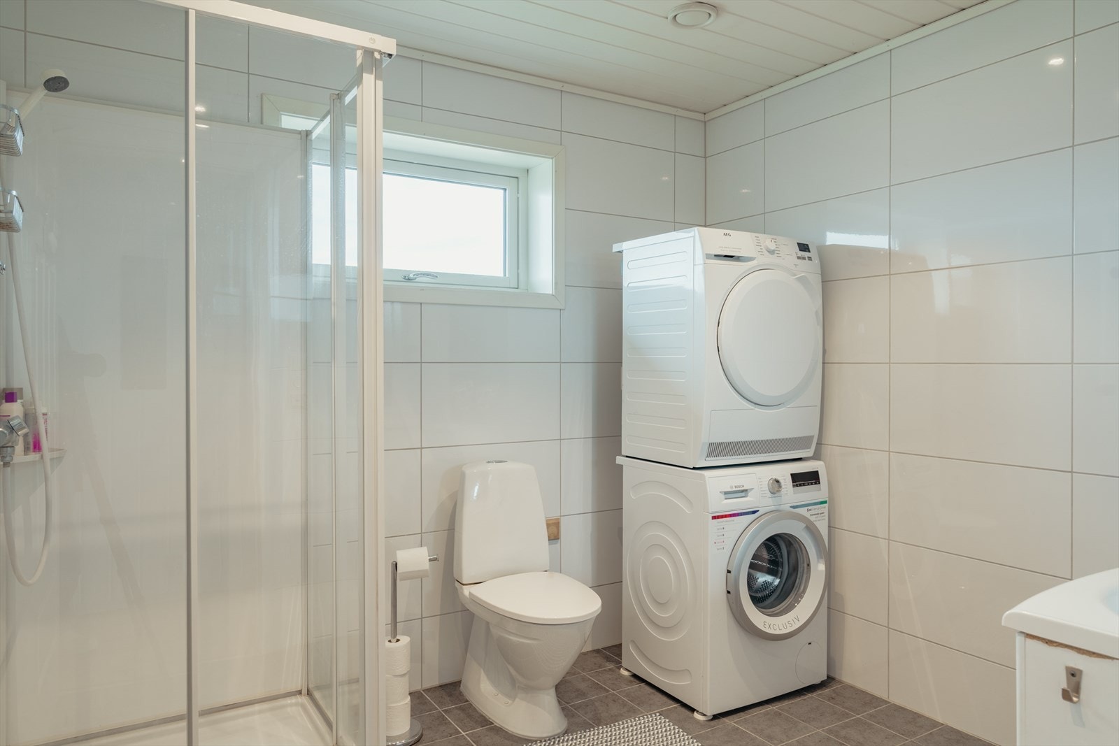 Tidløst og helfliset bad - god plass til både vaske- og tørkemaskin. Galleribilde