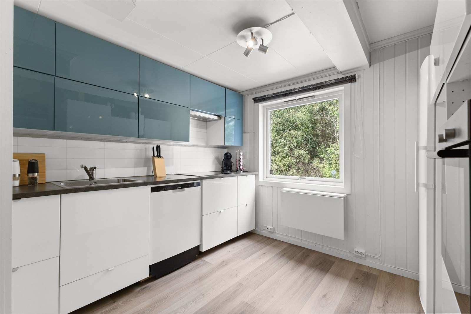 Kjøkkenet har innredning med slette fronter og benkeplate i laminat. Den nedfelte oppvaskkummen gir et stilrent og praktisk preg. Galleribilde