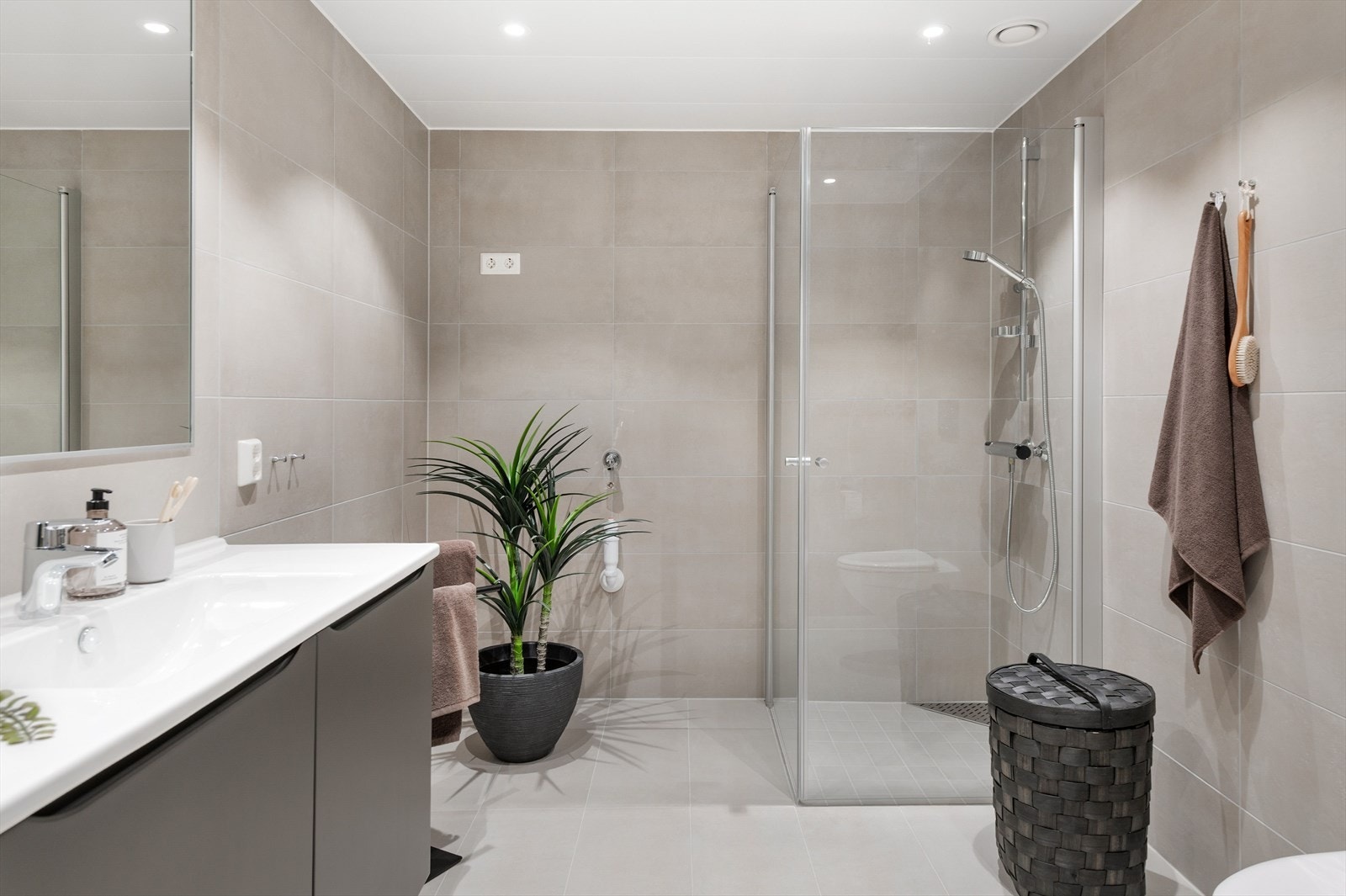 Lekkert flislagt bad med opplegg til vaskemaskin. Galleribilde