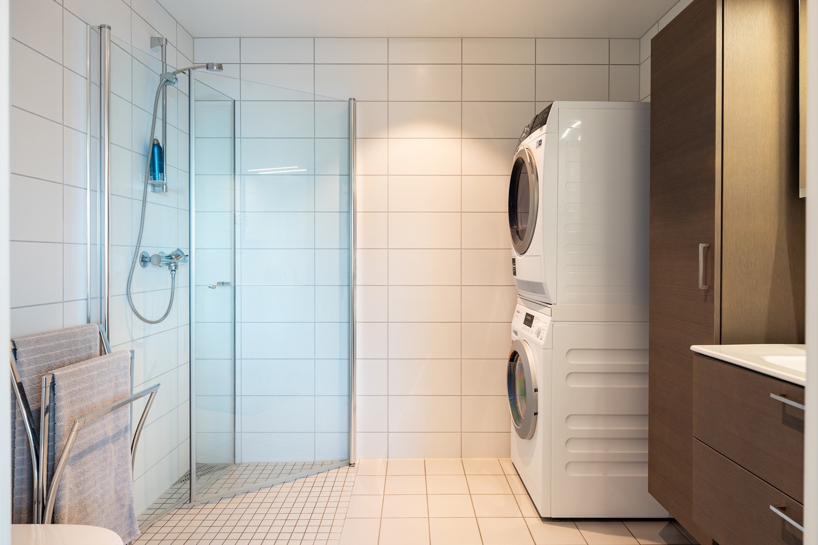 Flislagt og moderne baderom på 5,5m². Badet innehar kvaliteter som varme i gulv, innfellbare dusjdører, downlights i himling og opplegg for vaskemaskin. Også på badet er det gjort tilvalg på blant annet kran og WC. Galleribilde