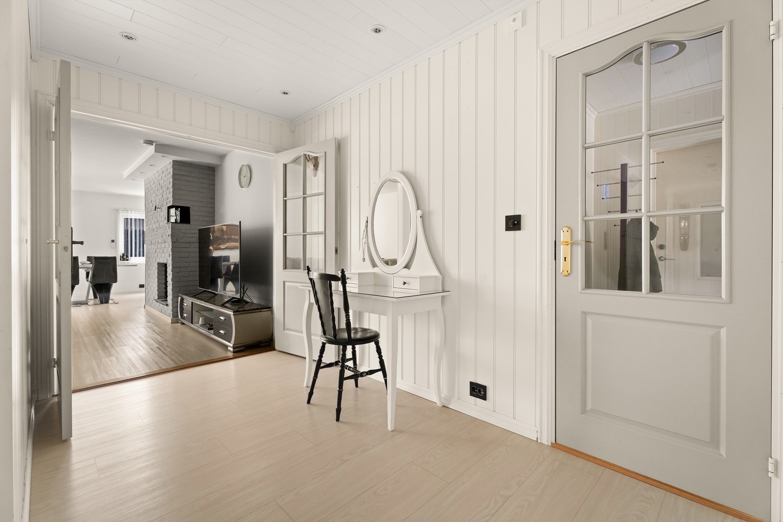 En glassdør skiller gangen fra stuen og bidrar til å slippe lys mellom rommene. Galleribilde