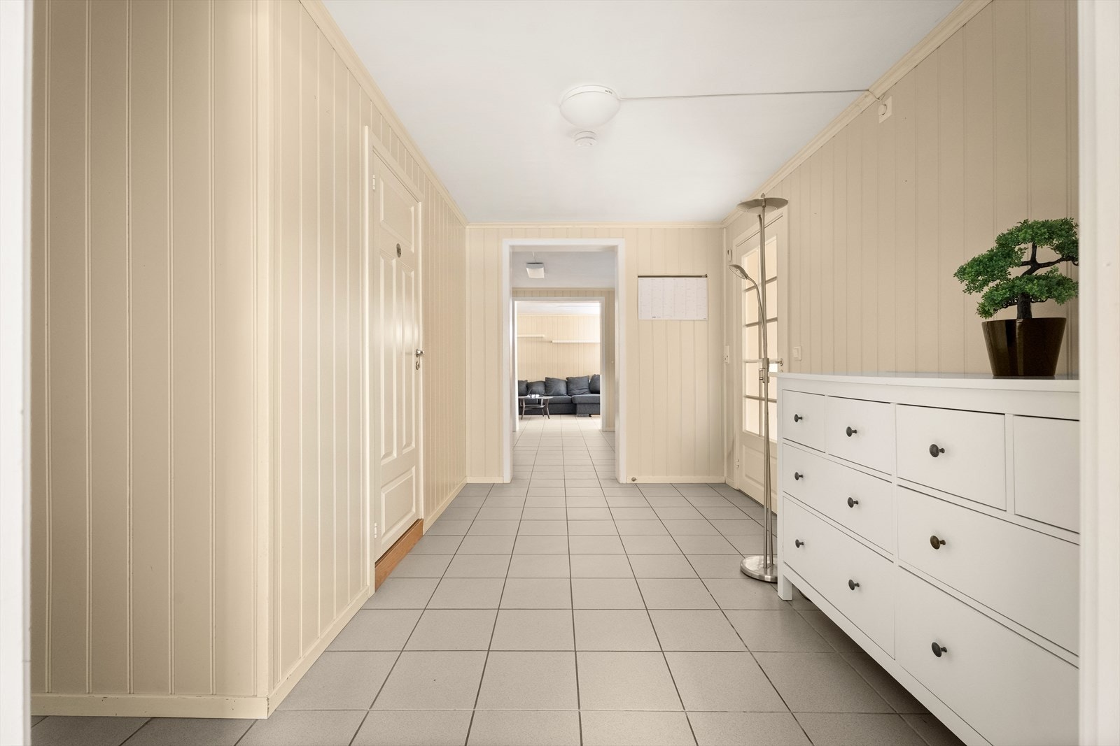 Inngangspartiet i kjelleren er romslig med flislagt gulv og panelplater på veggene. Galleribilde