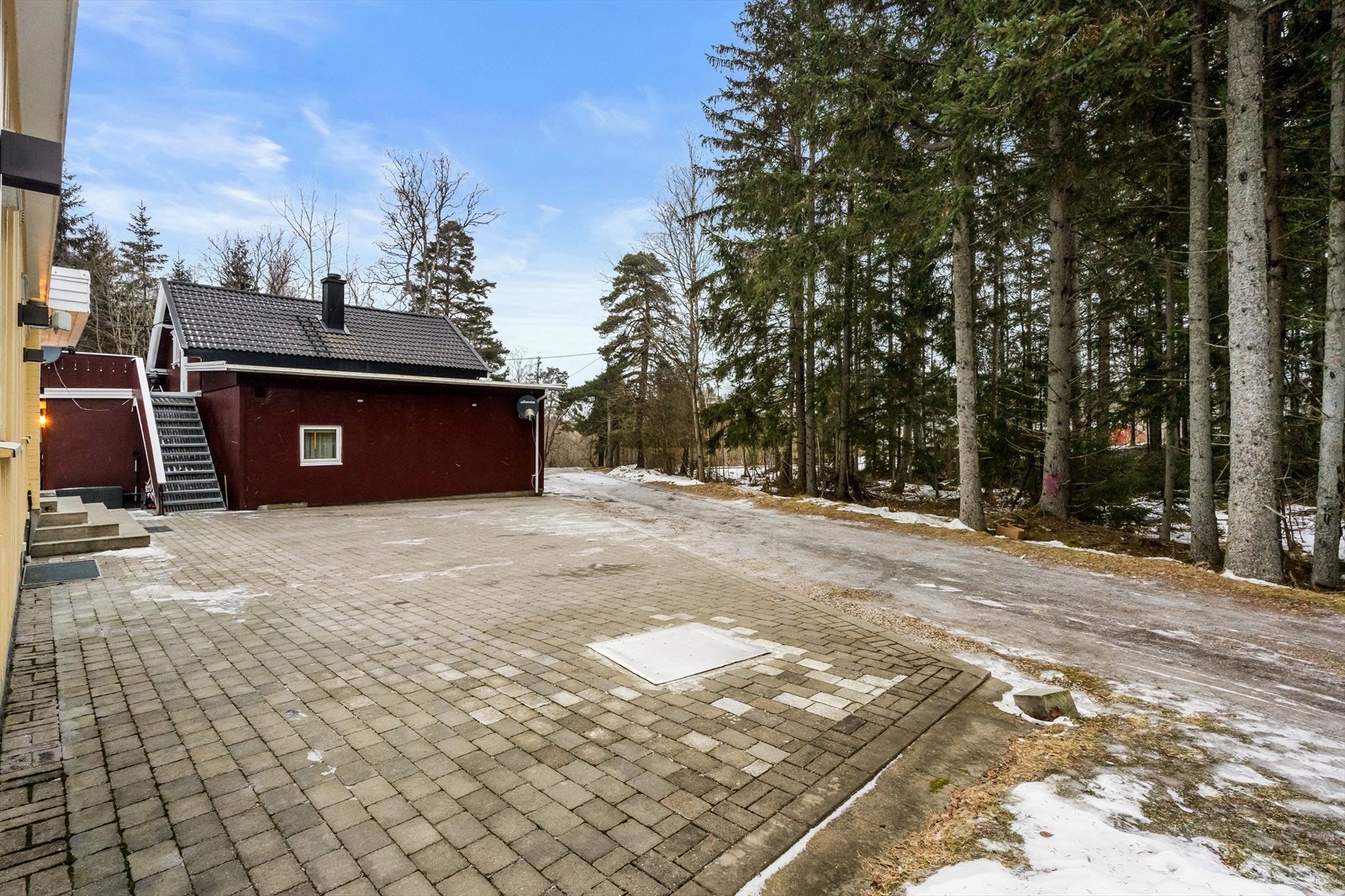 Eiendommen har en stor, belegningssteinbelagt gårdsplass og en frittstående bod på 14 m². Galleribilde