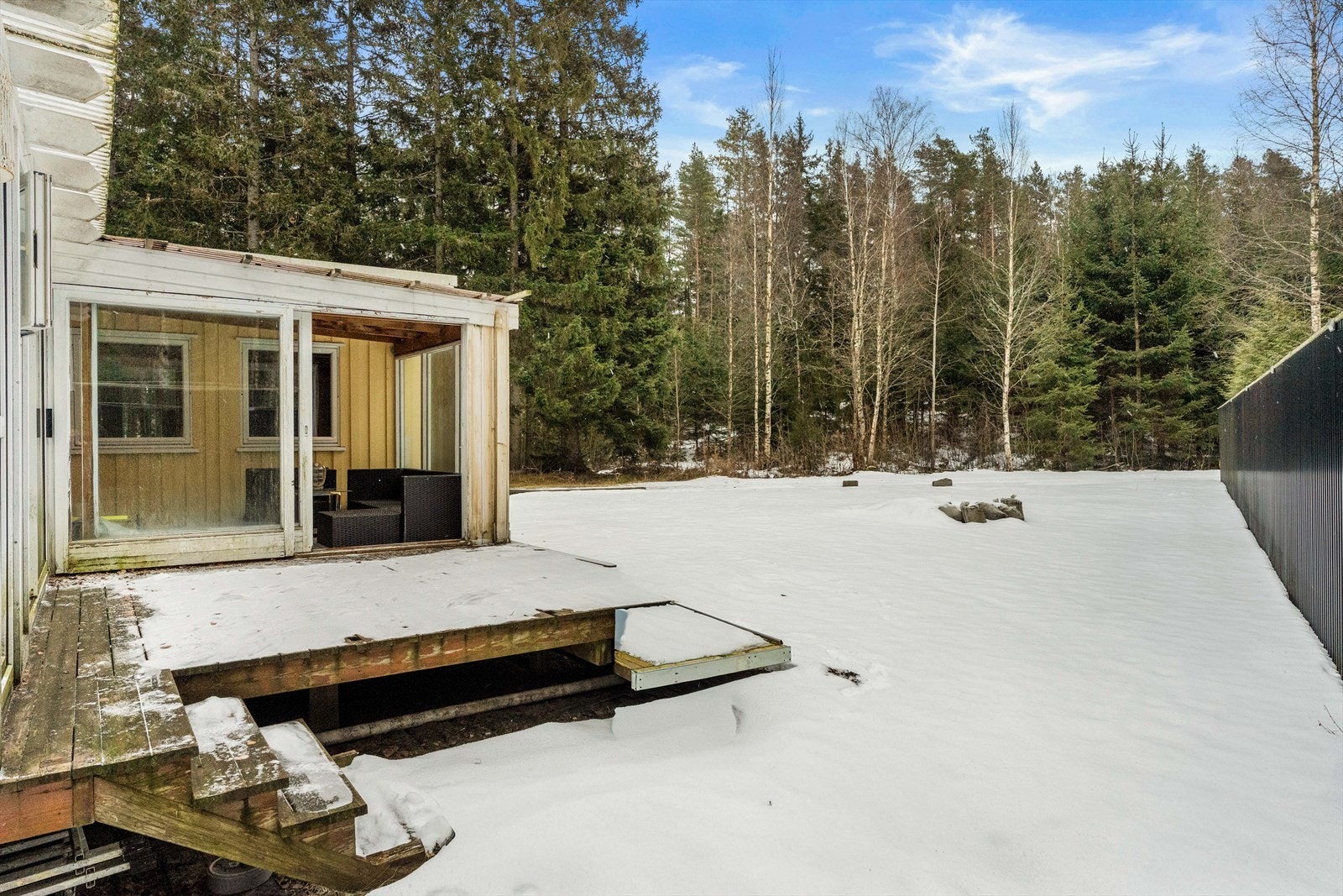 Fra den innglassede delen er det utgang til en åpen, sørvestvendt terrasse på 11 m². Tomten er opparbeidet med hage og grenser mot et skogholt. Galleribilde
