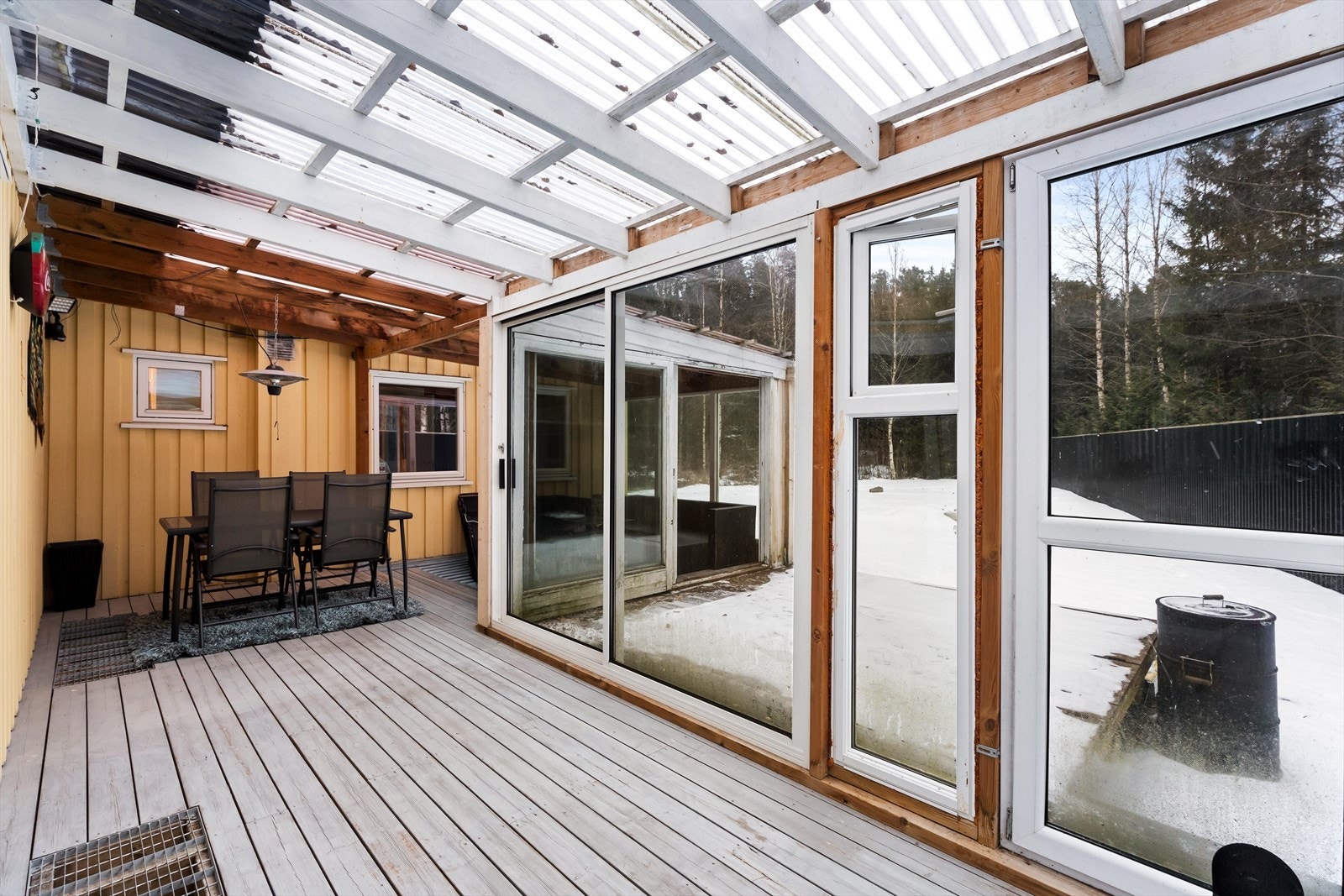Terrassen har beiset tregulv og tak av plastplater. Galleribilde