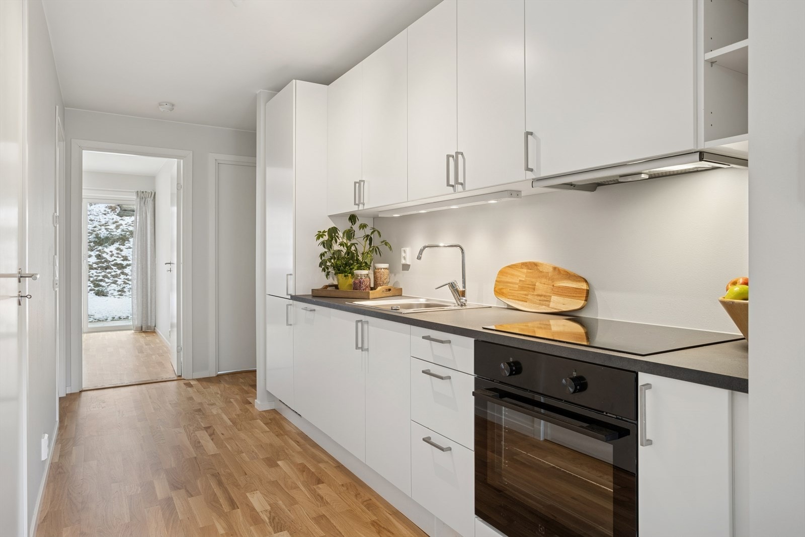 Moderne og funksjonelt kjøkken med glatte fronter og laminert benkeplate Galleribilde