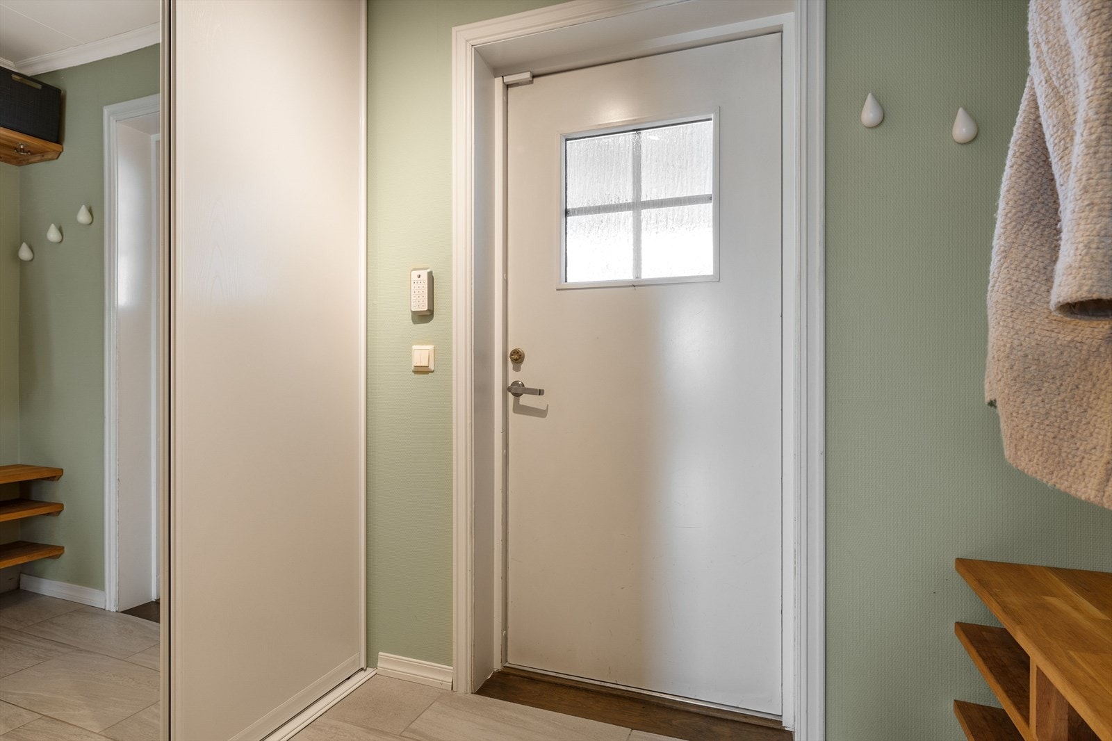 Entré med plassbygget garderobeløsning med hyller og heng, samt romslig skyvedørsgarderobe. Galleribilde