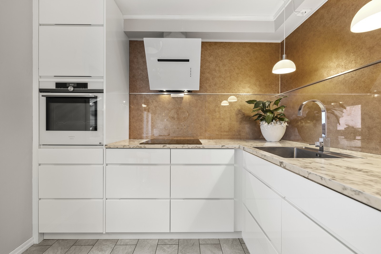 Kjøkkeninnredningen har slette, lyse fronter og en laminatbenkeplate. Galleribilde