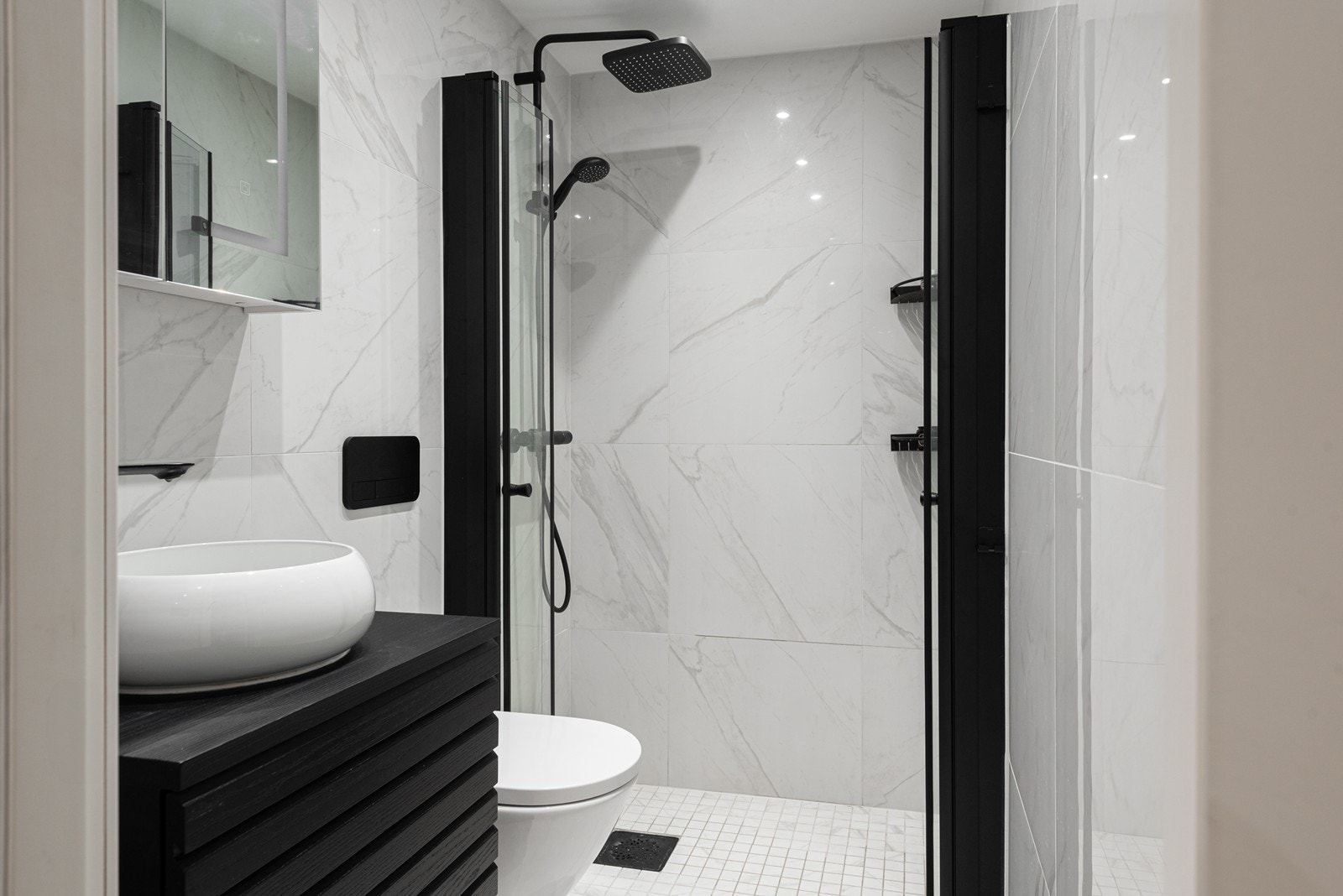 Lekkert bad med vegghengt toalett og dusjnisje med innsvingbare glassdører. Badet ble pusset opp i 2023 Galleribilde