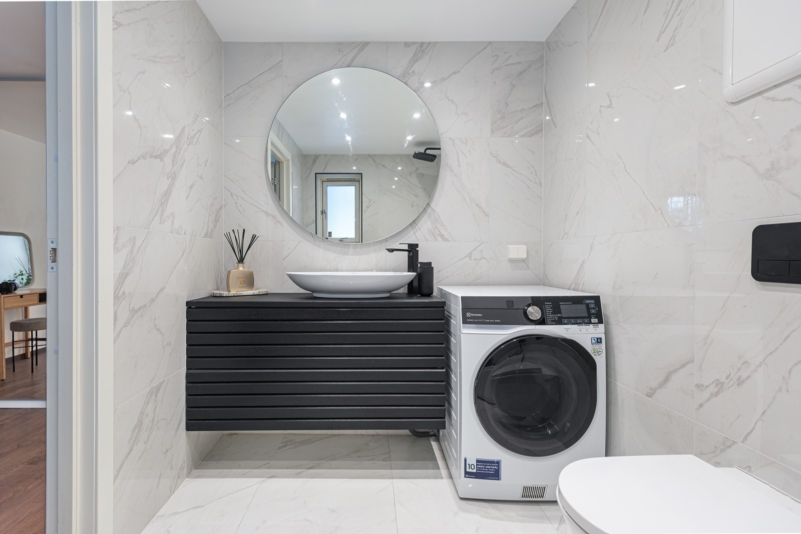 Moderne skapinnredning med spilefronter og frittstående servant. Gjennomgående sort utførelse på armaturer, profiler, slukrister og detaljer gir et helhetlig preg Galleribilde