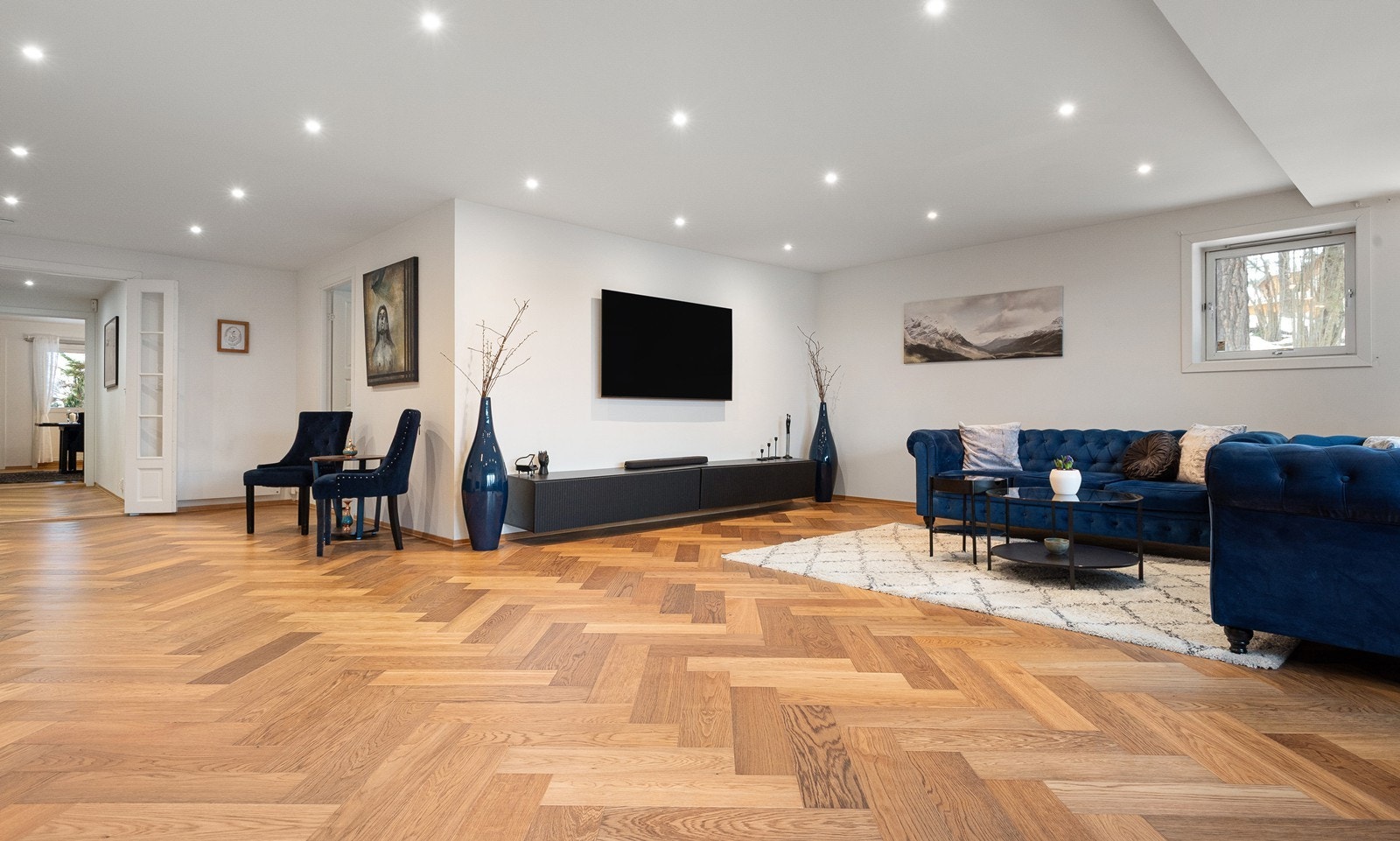 Stuen fremstår innbydende med lekker fiskebensparkett i eik, slette malte veggflater og downlightsbelysning i himling Galleribilde