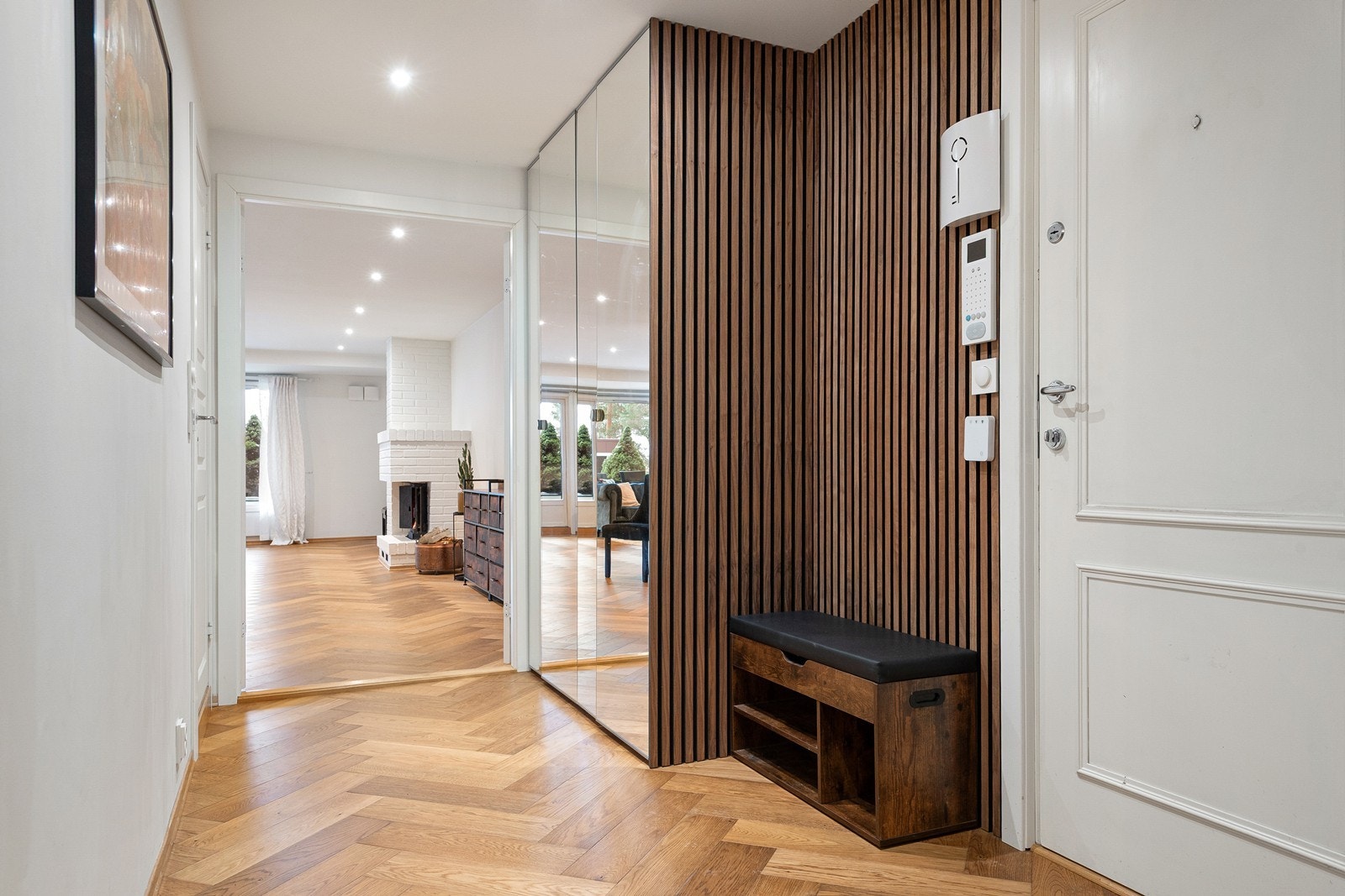 Entré med fiskebensparkett i eik, lysmalte veggflater og downlightsbelysning. Spilevegg og garderobeskap med speilfronter Galleribilde