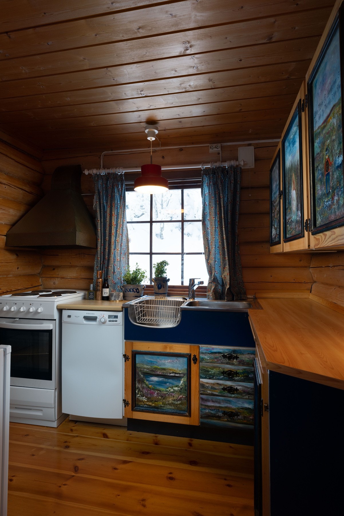 Sjarmerende kjøkken med dekorative fronter, utstyrt med komfyr, kjøleskap og oppvaskmaskin. Galleribilde