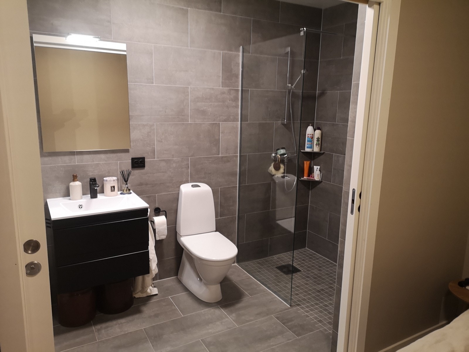 Romslig bad med dusjhjørne og vaskemaskin Galleribilde