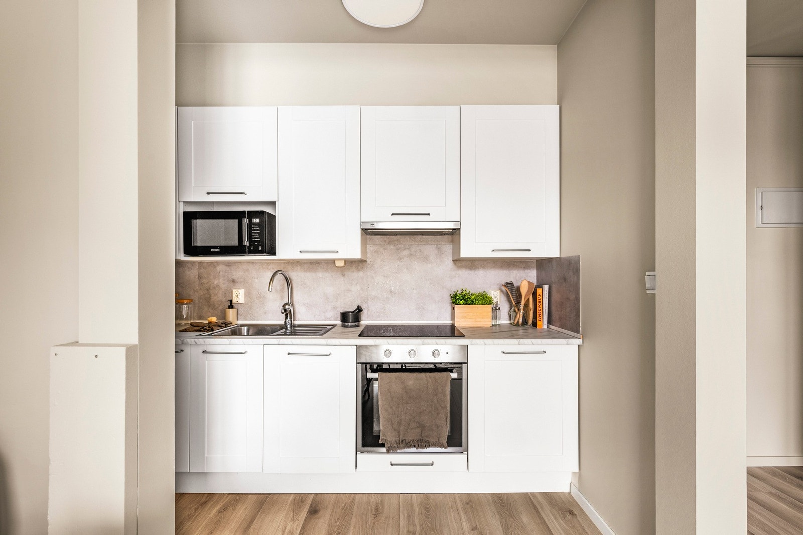 Av integrerte hvitevarer inneholder kjøkkenet induksjonsplatetopp, stekeovn og oppvaskmaskin. Galleribilde