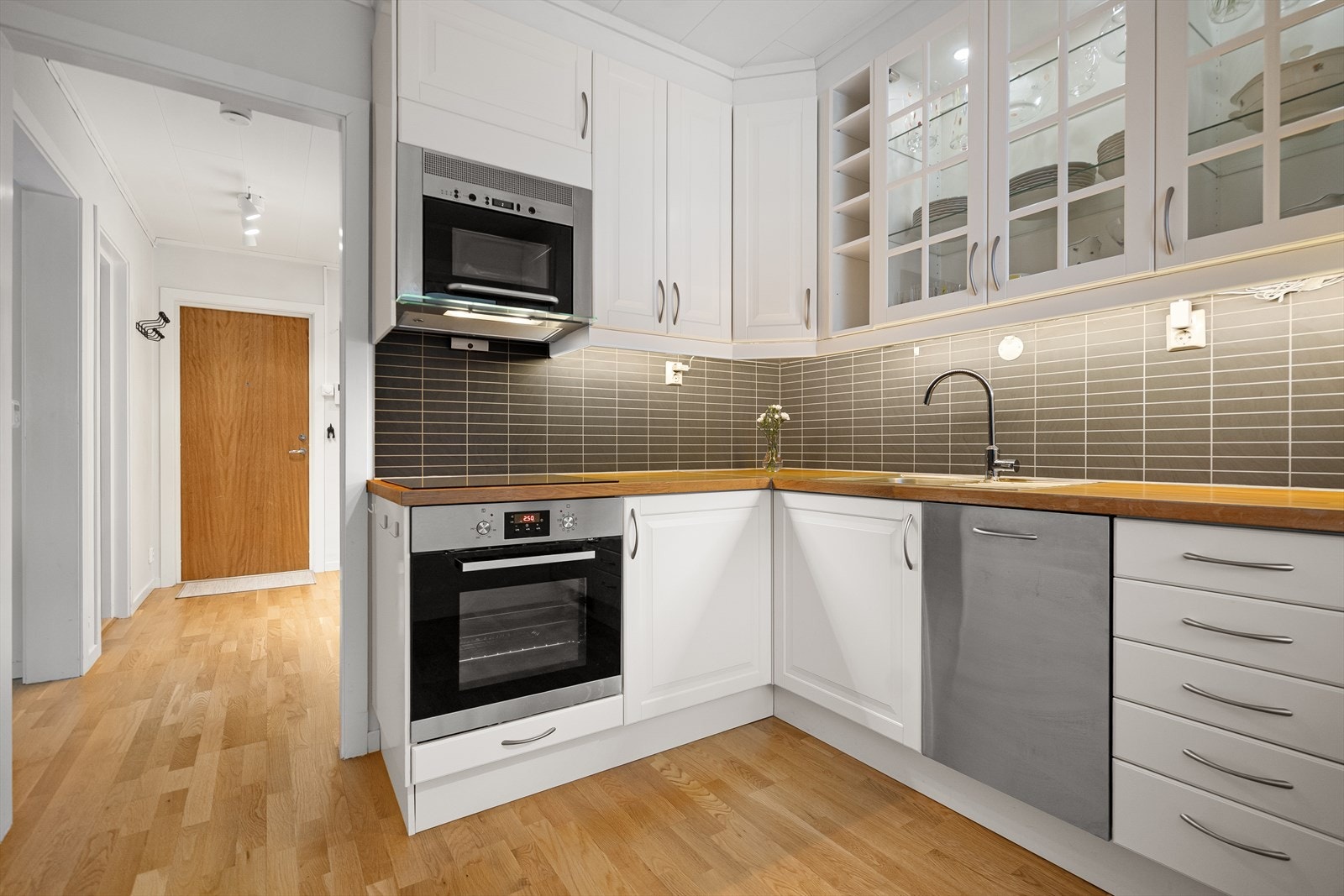 Pent kjøkken med profilerte fronter og integrerte hvitevarer Galleribilde