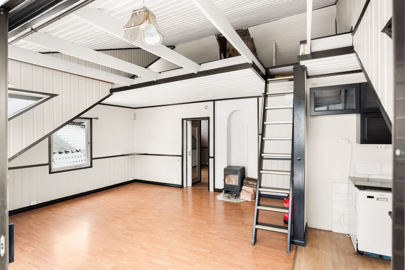 Lyst rom med peis, hems og trapp. Store vinduer gir godt lysinnslipp. Galleribilde