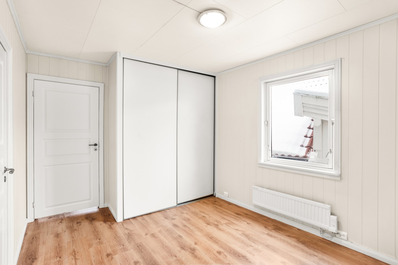 Rommet har lyse overflater og nyere skyvedørsgarderobe Galleribilde