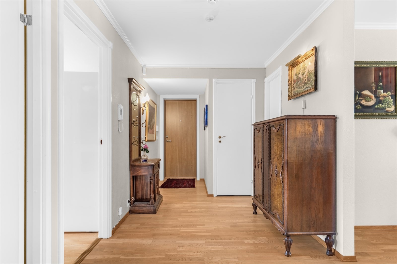 Innbydende entré med praktiske gulvflater og lyse vegger og himling som gir en luftig og hyggelig atmosfære. Her er det god plass til både yttertøy og sko, med mulighet for garderobeløsning eller annen smart oppbevaring. Galleribilde