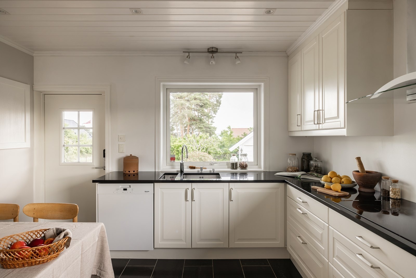 Kjøkkenet er romslig og effektivt innredet, med rikelig skap- og benkeplass, integrerte hvitevarer og mekanisk avtrekk Galleribilde