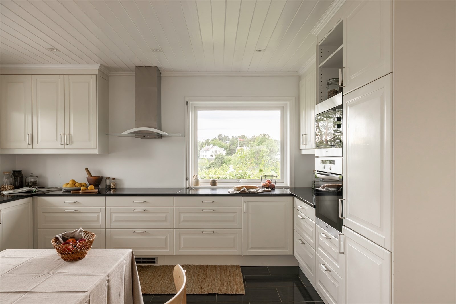 Gulvet er flislagt med gulvvarme, og himlingen har malt panel og downlights. Galleribilde