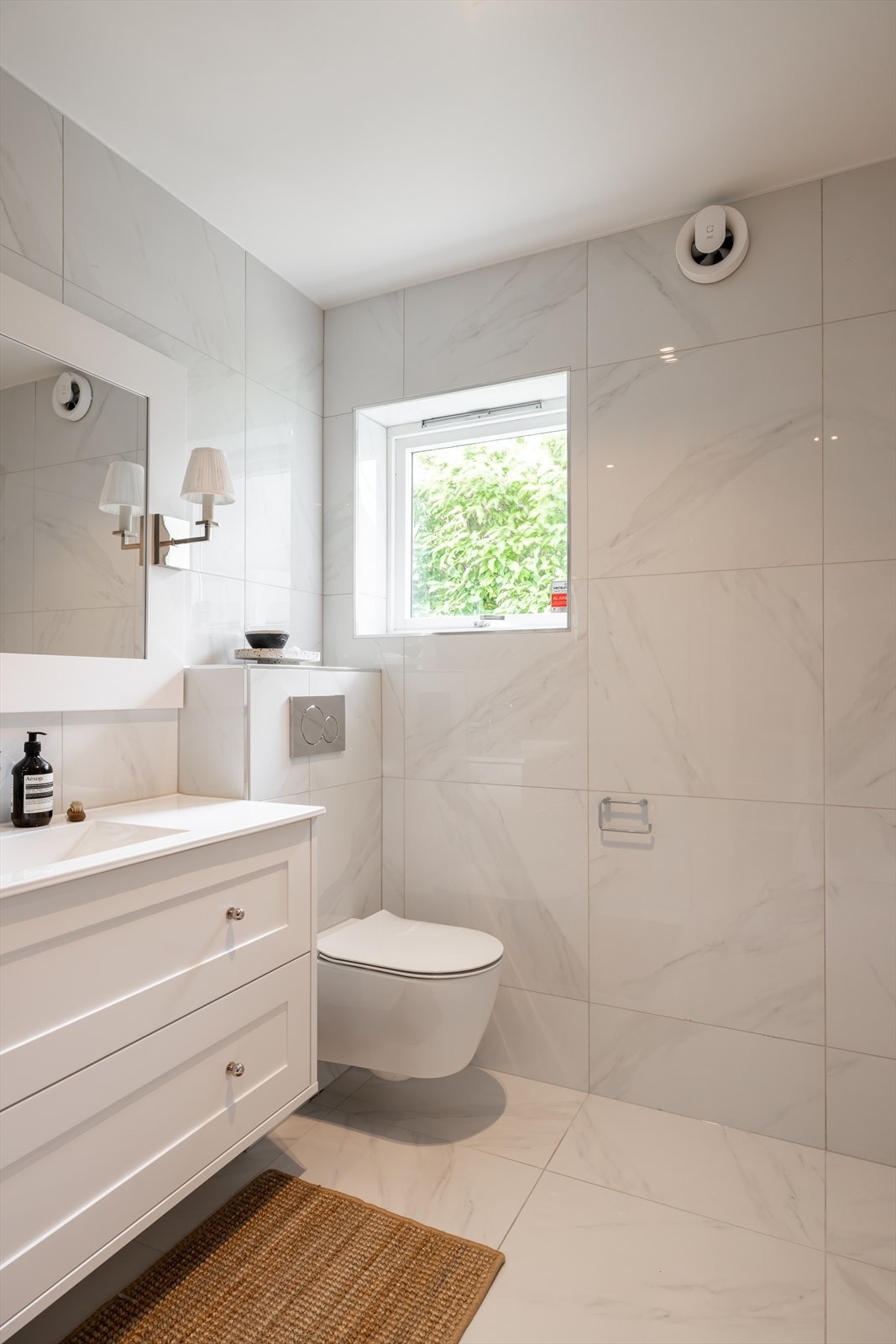 Store, lyse fliser på gulv og vegger gir rommet et tidløst og innbydende uttrykk. Galleribilde